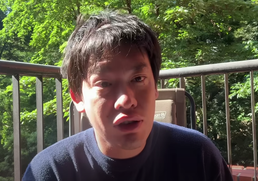 外で椅子に座って話す箕輪厚介