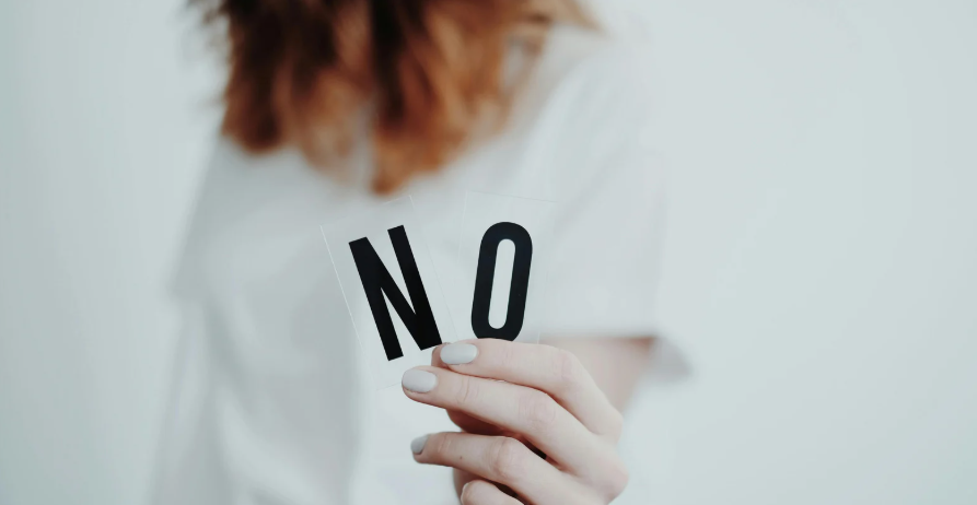 NOの札をもつ人の画像