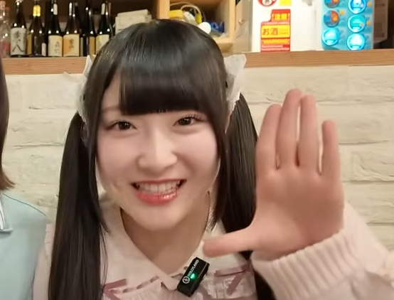 左手をあげて笑う櫻井もも
