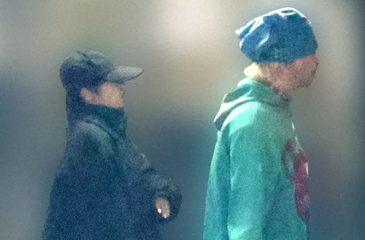 緑のトレーナー着ている深瀬さんと、並んで歩く黒いキャップの女性